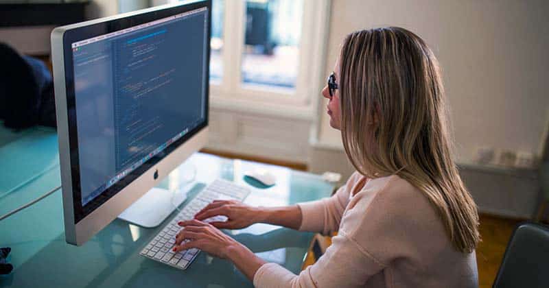Woman working on computer with large monitor